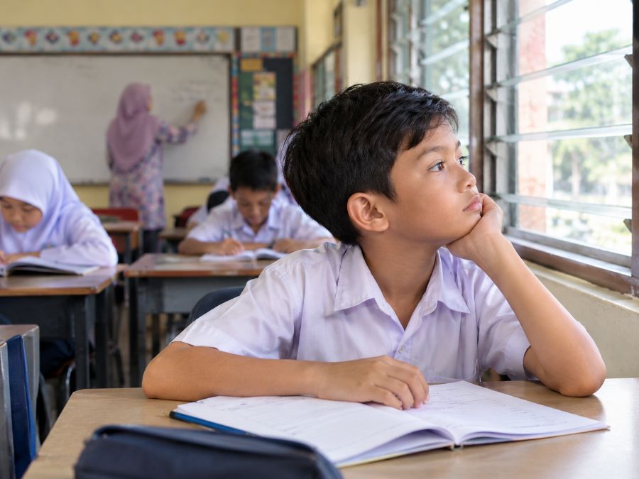 Murid memandang ke luar tingkap semasa cikgu mengajar di kelas